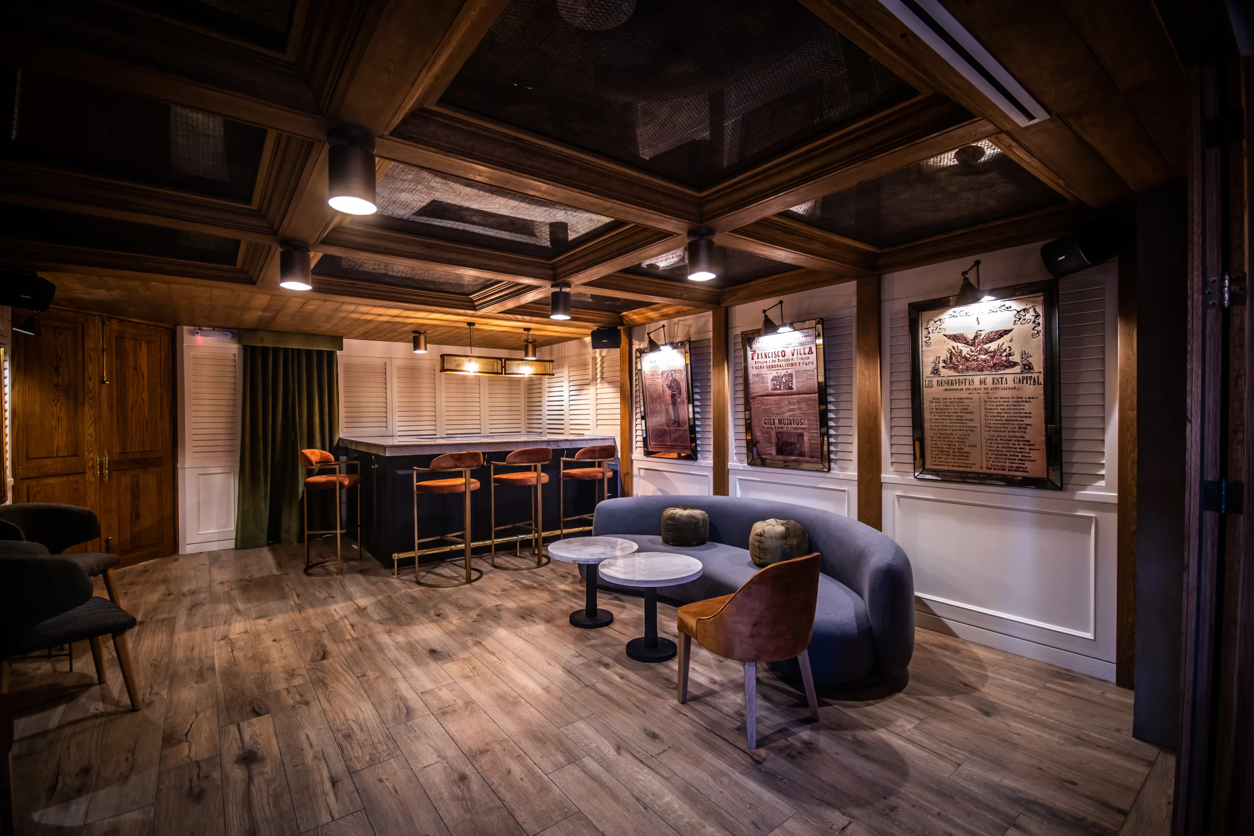 hay una habitación con un sofá mesa sillas y un bar