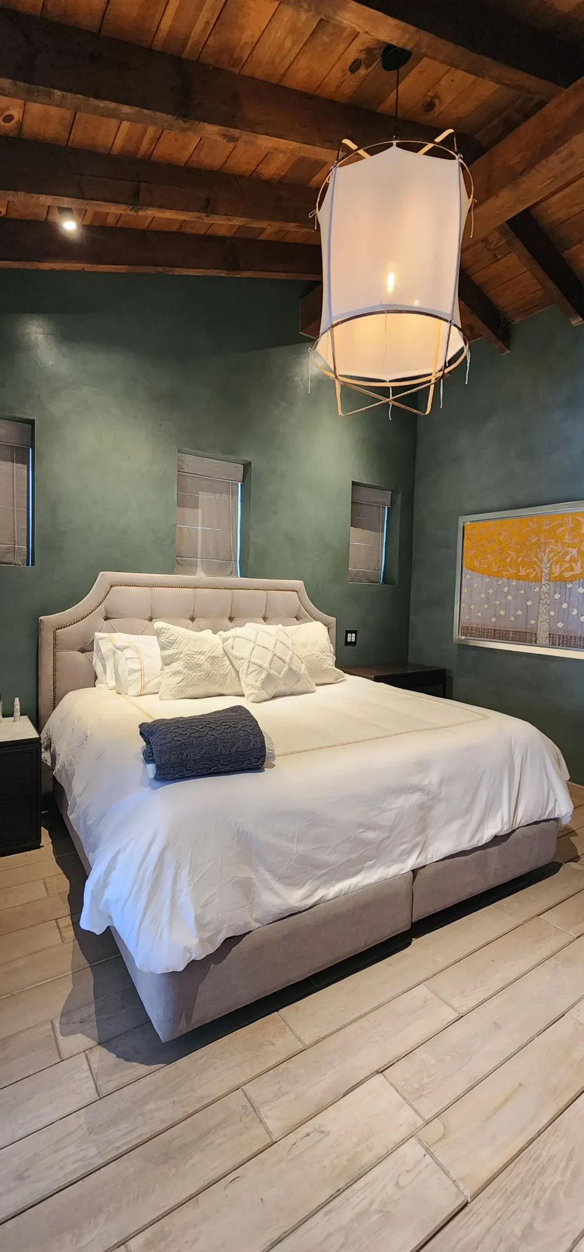 hay una cama con un edredón blanco y una manta blanca