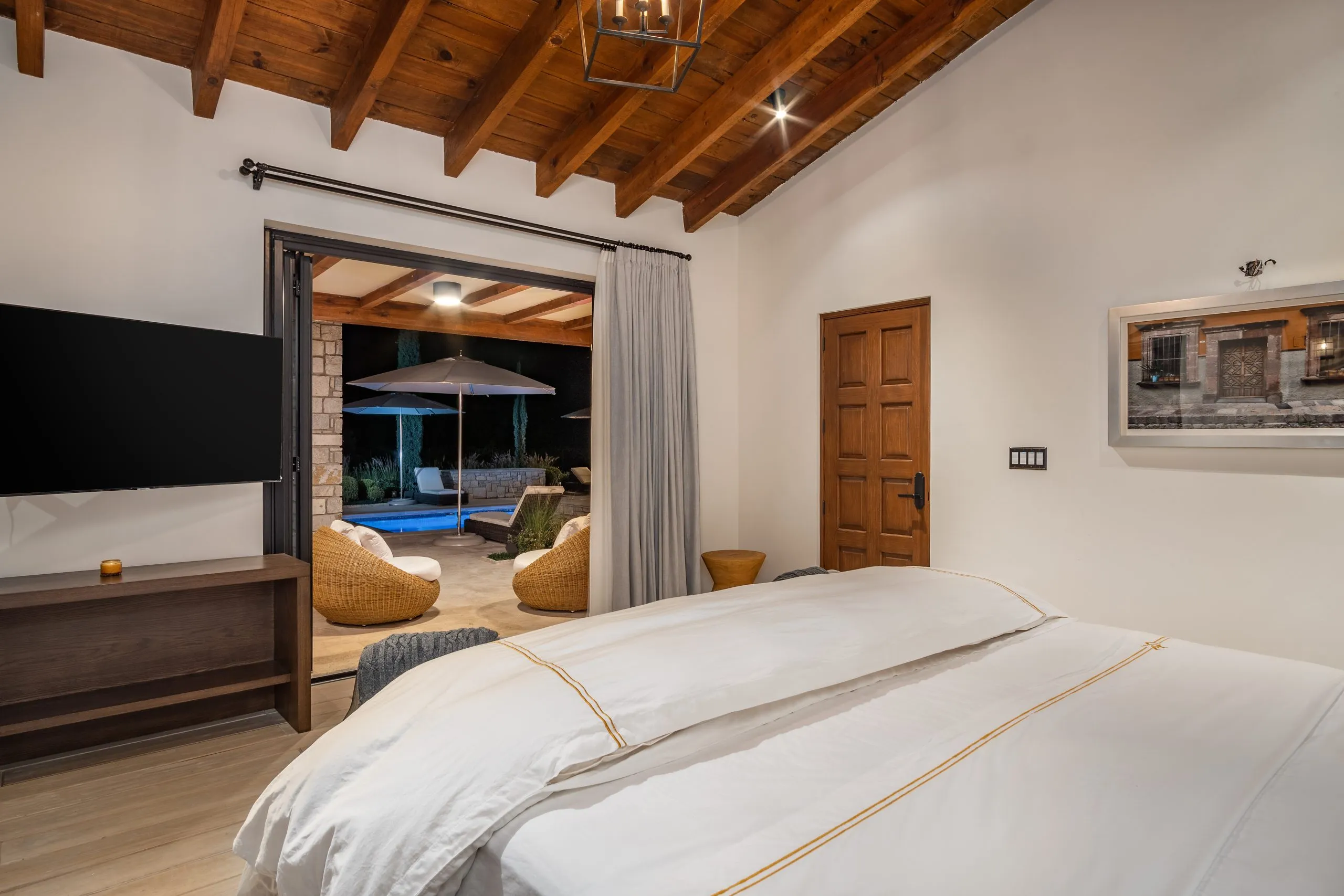 hay una cama con sábanas blancas y almohadas en un dormitorio