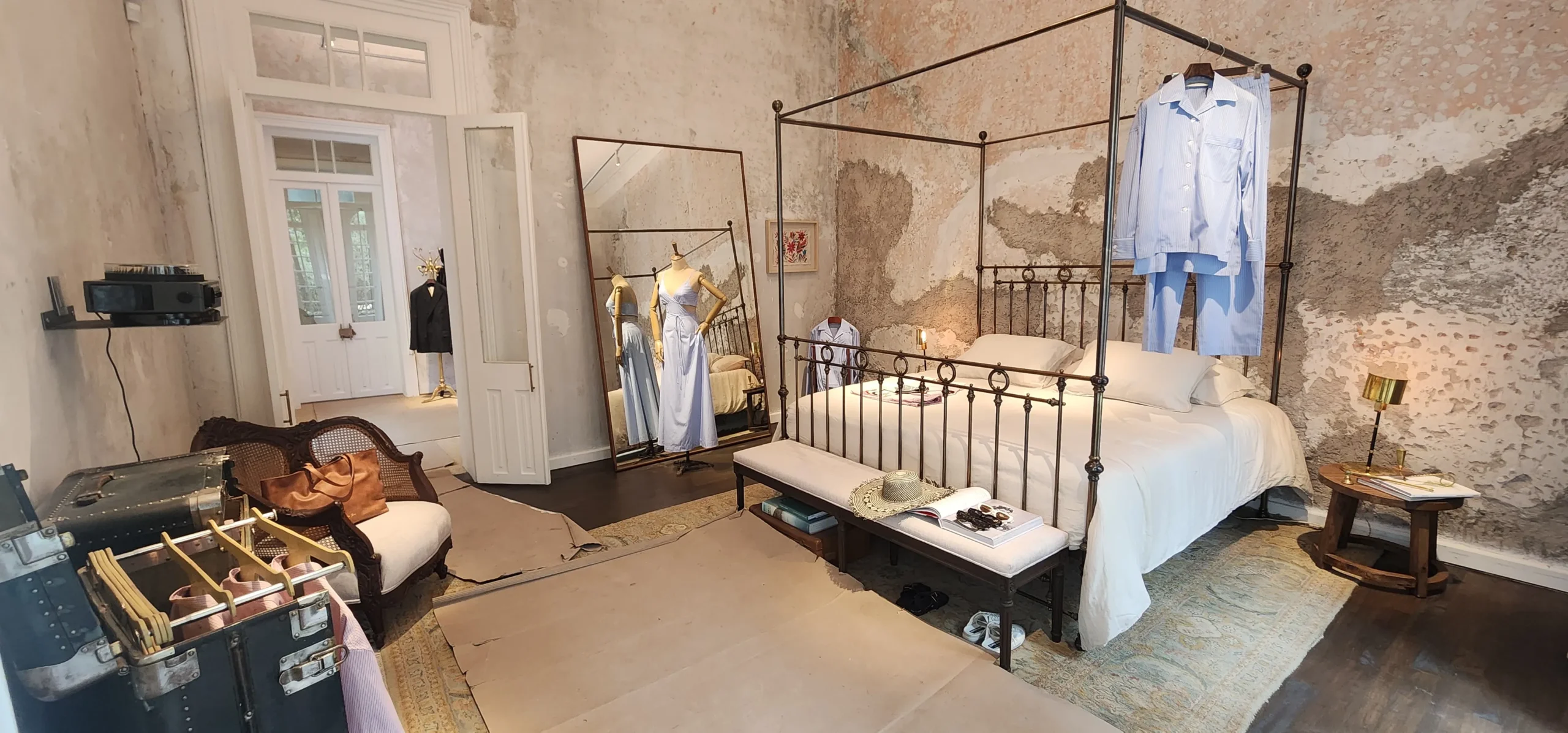 hay una cama con dosel en una habitación con un papel pintado