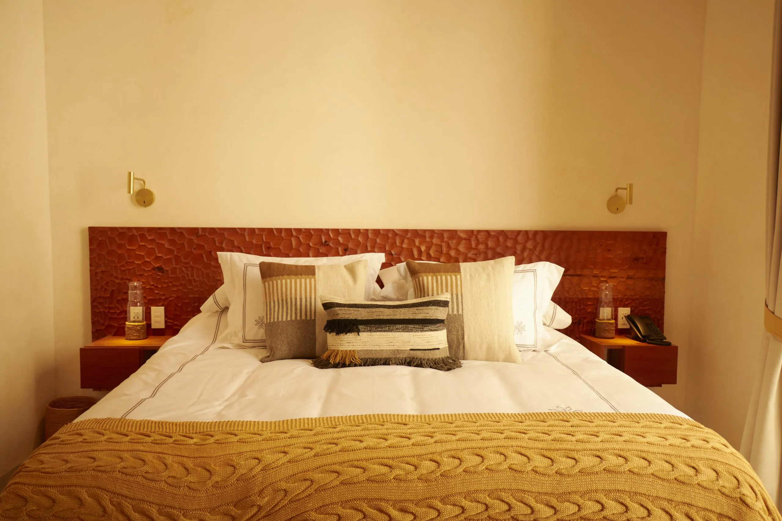 hay una cama con una cama cuidadosamente hecha y una ventana