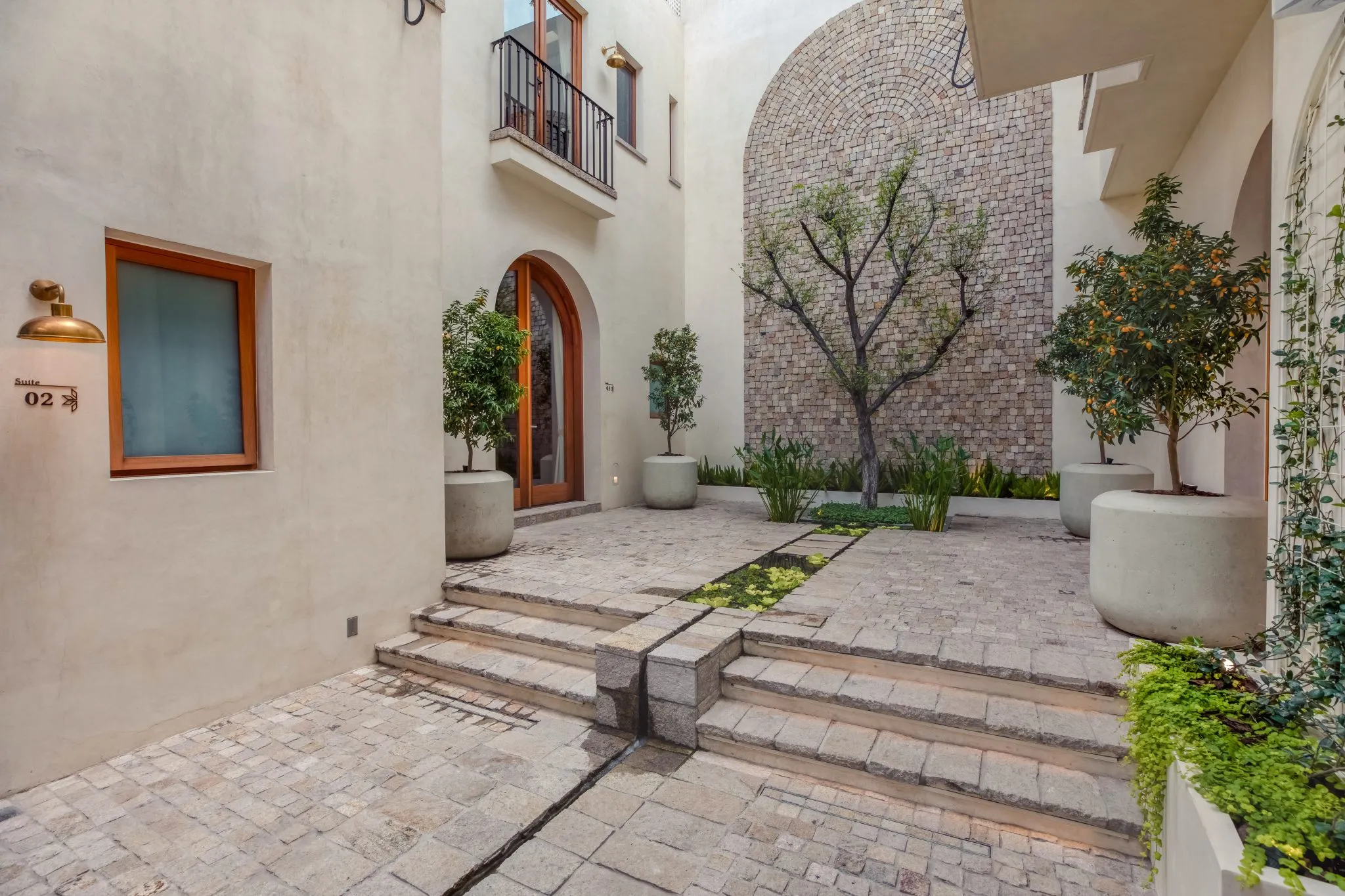 hay un patio con una pasarela de piedra y una escalera de piedra