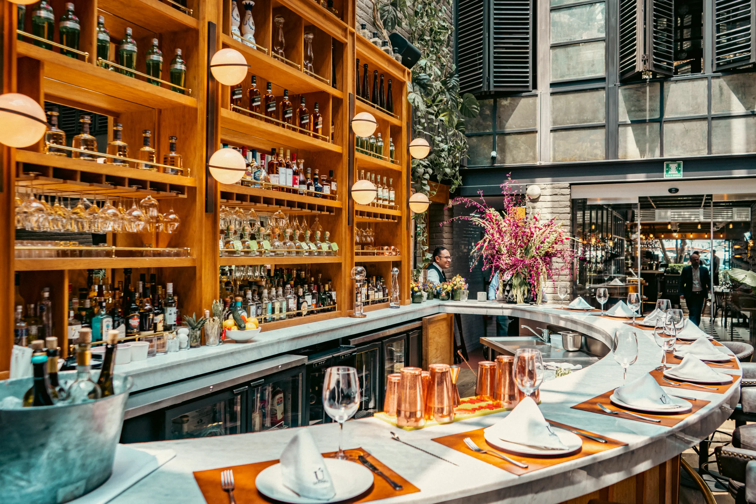 hay un bar con un montón de botellas y vasos en él