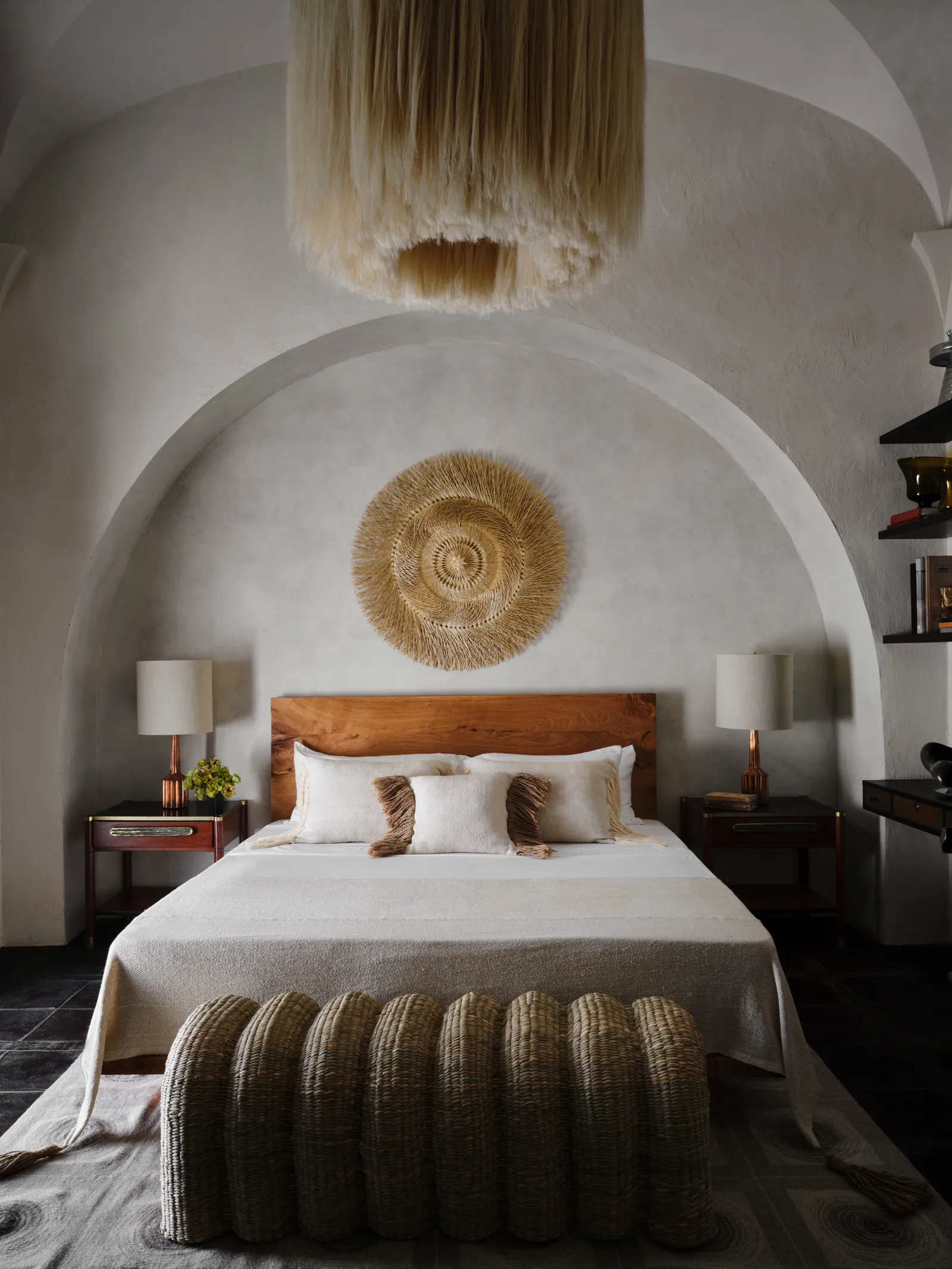 una cama con una cabecera grande y una lámpara grande encima de ella