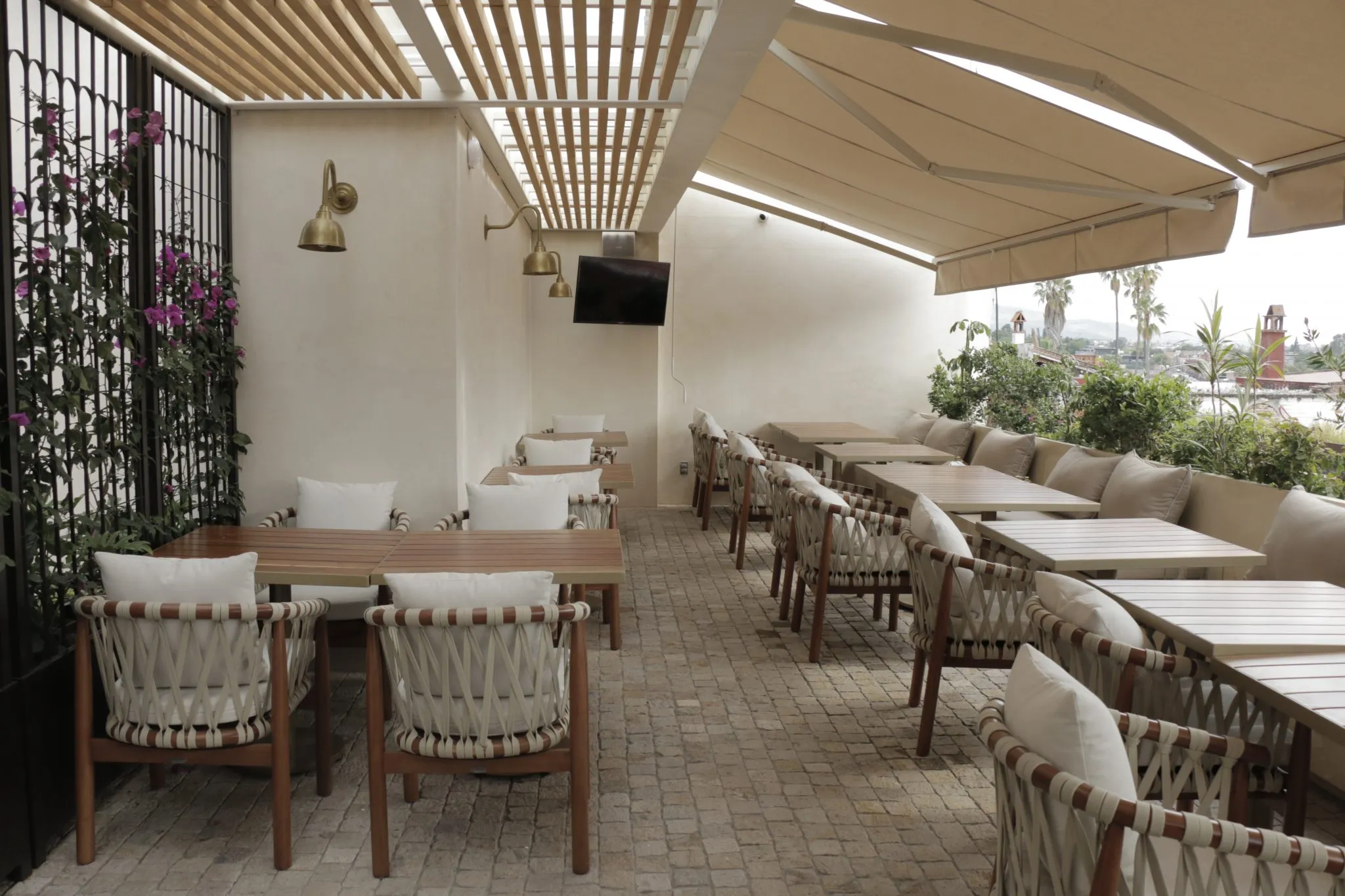 mesas y sillas están alineadas en un patio con un televisor