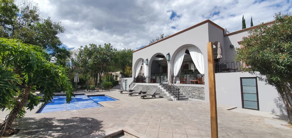 Una portada de una lujosa casa con piscina y cortinas automatizadas