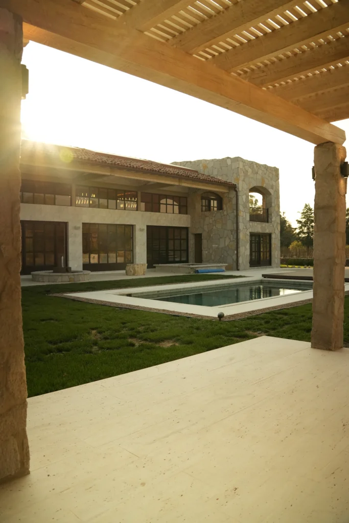 Un portal de una casa con piscina e iluminación interna del hogar