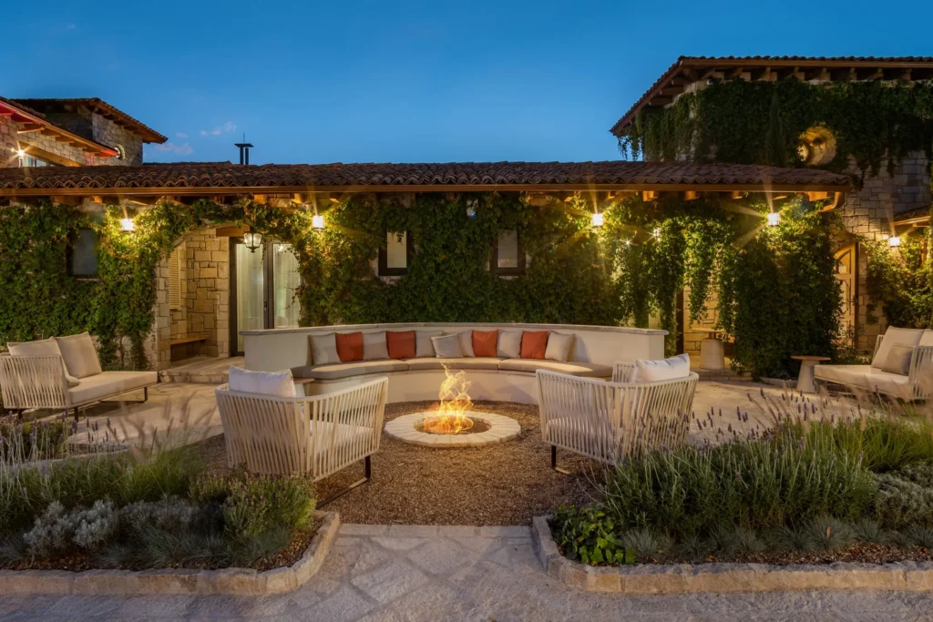 Un hermoso patio con fogata a la luz de la tarde con luces directas